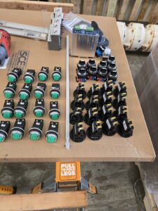 Control panel components (pilot lights, selector switches, relays) for a lift station panel build